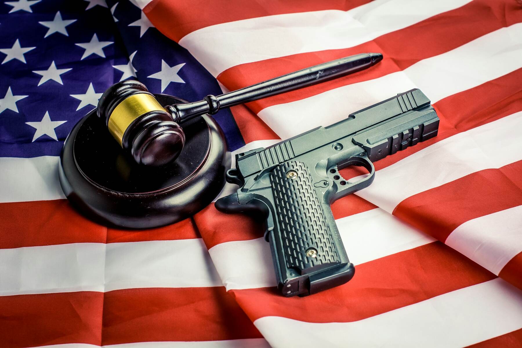 A gun and a judge's gavel on an American flag